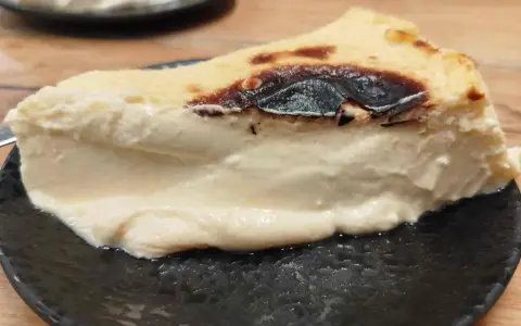 Rebanada cremosa de pastel vasco, con su característico exterior tostado y un interior suave y delicioso.