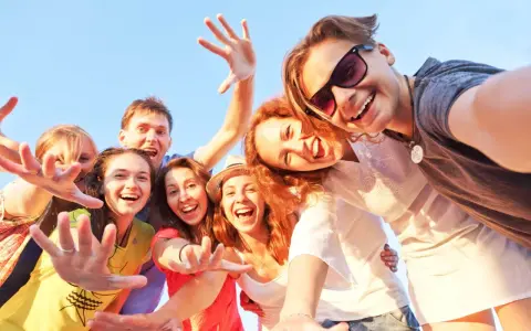 Uśmiechnięta grupa przyjaciół robi selfie. Ich radość i bliskość to czynniki chroniące przed samotnością.