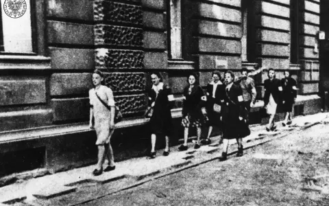 Kobiety w powstaniu warszawskim, idące ulicą. Na ramionach mają opaski.