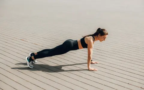 Femme en tenue de sport faisant une planche, un excellent exercice pour perdre du ventre.