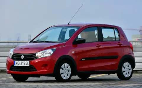 Czerwony Suzuki Celerio z polskimi tablicami rejestracyjnymi WB 2175L zaparkowany na zewnątrz.