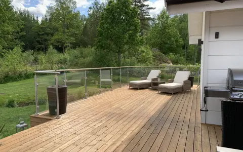 Träaltan med solstolar och grill. För att bevara träets skönhet, fundera på hur ofta olja altan.