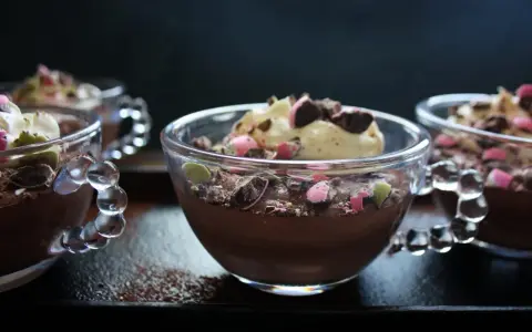 Chokladmousse recept i små glasbägare, toppad med grädde och krossad choklad. En perfekt dessert!