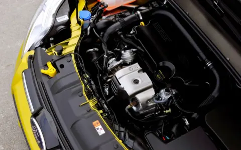 Silnik 1.0 Ecoboost w żółtym Fordzie. Widoczne elementy układu dolotowego, turbosprężarki i osłony silnika.