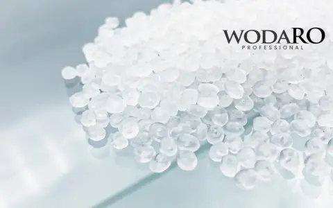 Granulat polipropylenowy WODARO PROFESSIONAL. Czyste, białe granulki tworzą tło dla logo.
