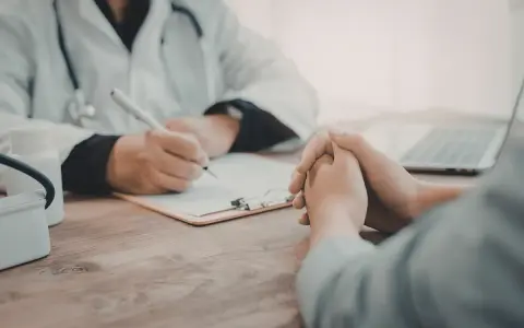 Consultation médicale : un médecin note des informations sur une liste maladie professionnelle secrétaire.