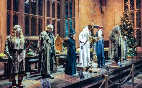Manekiny postaci z Harry'ego Pottera w strojach, w tym Hagrid i Dumbledore, obok choinki.