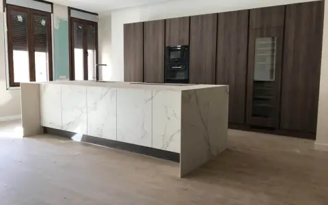 Isla de cocina moderna con encimera de mármol y armarios oscuros. Se aprecian las medidas de los muebles de cocina en el diseño.