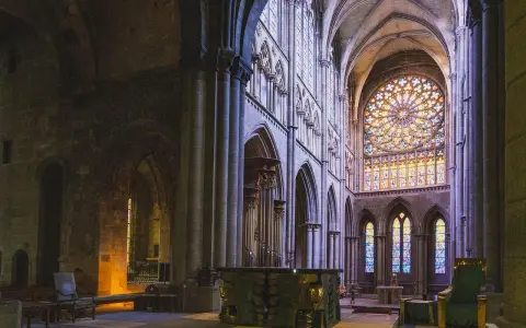 Wnętrze katedry z witrażami i ołtarzem. Miejsce sprzyjające refleksji nad teologią i duchowością.