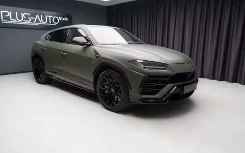 Matowy, zielony Lambo Urus z czarnymi felgami stoi w studiu.