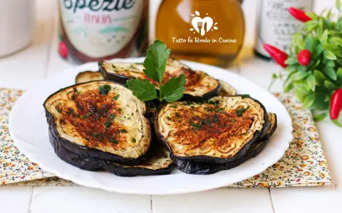 Fette di melanzane in friggitrice ad aria, dorate e profumate, pronte per essere gustate.