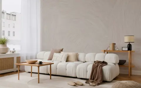 Minimalistyczny salon z sofą, stolikiem i lampą. Subtelne wzory na ścianie i dywanie podkreślają różnicę między stylem skandynawskim a japandi w oprawie eventu.
