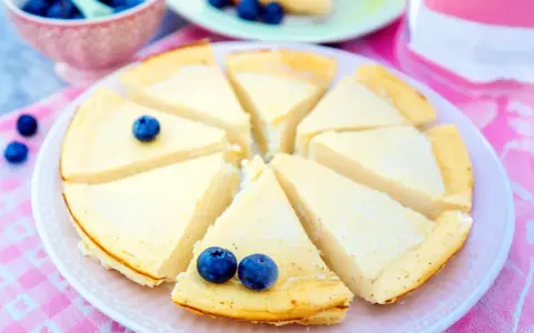 Ein köstlicher low carb Kuchen, in Stücke geschnitten und mit Blaubeeren garniert, wartet auf Genuss.