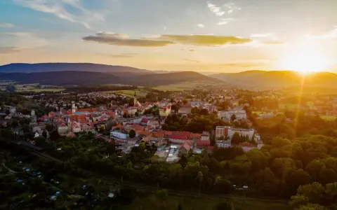 Zachód słońca nad Bystrzycą Kłodzką. Widok z lotu ptaka na miasto otoczone wzgórzami, idealna trasa na wieczorny spacer.