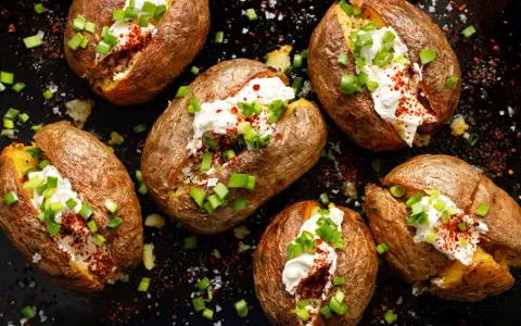 Kumpir Rezept: Gebackene Kartoffeln mit cremiger Füllung, Schnittlauch und Paprikapulver.