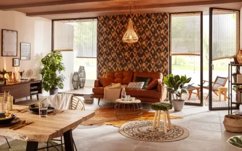 Gemütliches Wohnzimmer mit Ledersofa, Holztisch und afrikanische Muster an der Wand.
