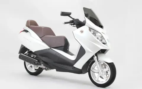 Biały skuter Peugeot Satelis z brązową kanapą, gotowy na miejskie przygody.