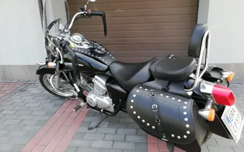 Czarny motocykl Honda Shadow z sakwami i oparciem. Zastanawiasz się, jaki silnik wybrać do tej maszyny?