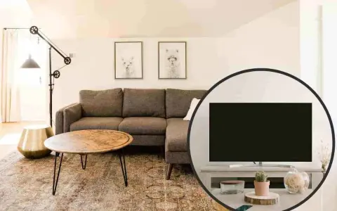 Salotto accogliente con divano angolare, tavolino e un'inquadratura che mostra la tv non frontale al divano, con decorazioni.