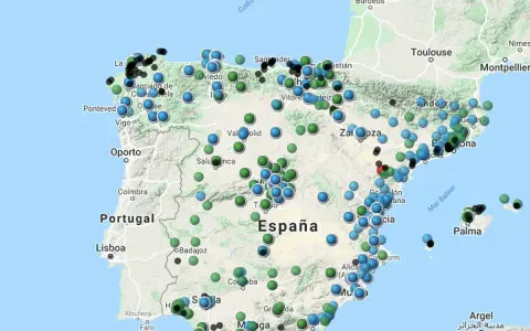 Mapa de España con puntos de colores que indican niveles de contaminacion atmosferica.