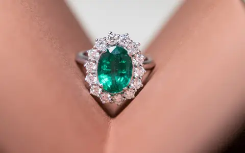 Anello con smeraldo ovale circondato da diamanti, un gioiello di grande valore, più prezioso di un rubino.