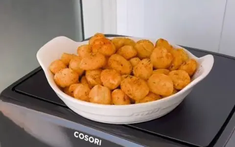 Ñoquis dorados y crujientes en una fuente blanca, recién salidos de la freidora de aire Cosori. ¡Perfectos para picar!