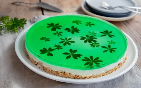 Grüne Philadelphia Torte mit Waldmeister-Gelee und zarten Blüten. Ein erfrischender Genuss!