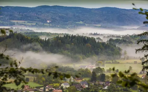 Mgliste poranki nad Sudetami. W oddali widać zamek, a niżej rozciągają się lasy i urokliwe miejscowości.