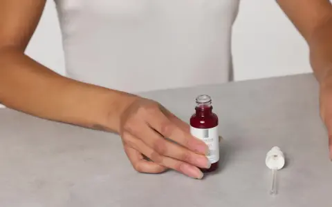 Mani che mostrano il siero Retinol B3 La Roche Posay, pronto per l'uso. Scopri come applicarlo per una pelle radiosa.
