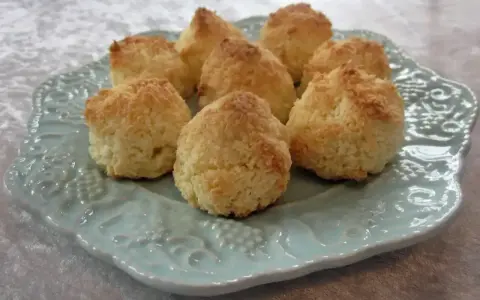 Gyllene kokostoppar på en vacker ljusblå tallrik. Perfekt för ett enkelt kokostoppar recept.
