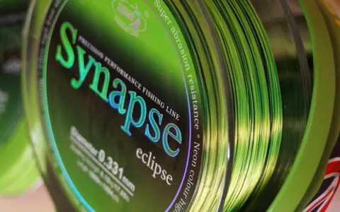 Jaka żyłka karpiowa do dalekich rzutów? Zielona żyłka Synapse Eclipse, 0.331mm, z napisem "Super abrasion resistance", idealna na długie dystanse.