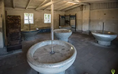 Wnętrze muzeum Stutthof z kamiennymi kadziami, które służyły do prania.