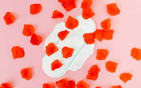 Compresa con pétalos rojos, simbolizando el sangrado después de la pastilla del día después.