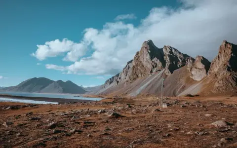 Surowe piękno Islandii. Góry, jezioro i sucha trawa. Nawet przy niskiej **temperatura Islandia** zachwyca.