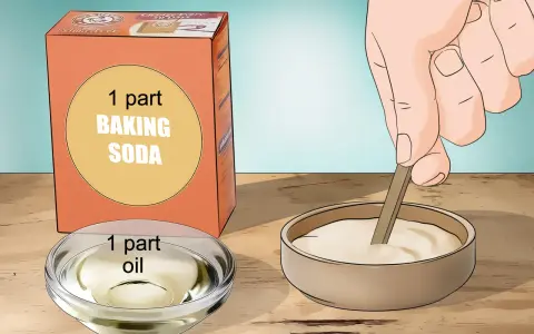 Learn how to remove acrylic glue using a paste of baking soda and oil. A hand mixes the paste in a bowl.