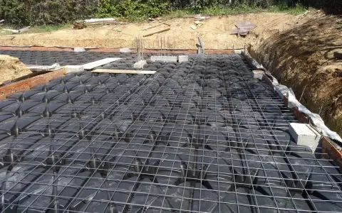 Preparación para un forjado sanitario ventilado: se aprecian los casetones negros y la malla metálica sobre ellos.