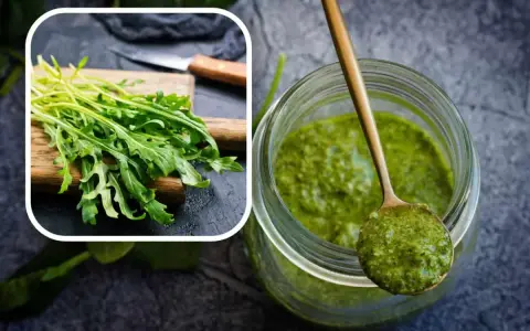 Un mazzetto di rucola fresca su un tagliere e un barattolo pieno di vibrante pesto di rucola, pronto per insaporire i tuoi piatti.