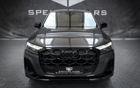 Przód ciemnoszarego Audi Q7 z czarnym grillem i światłami LED.