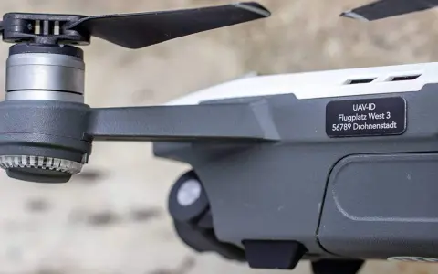 Nahaufnahme einer e-id drohne mit Propeller und Aufkleber "UAV-ID Flugplatz West 3 56789 Drohnenstadt".