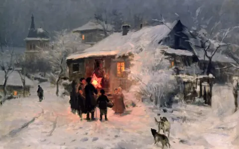 Cicha noc, historia kolędy. Grupa ludzi z gwiazdą na patyku idzie przez zasypaną śniegiem wieś.