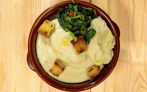 Fave e patate, ricetta pugliese: purè cremoso con verdure verdi e crostini dorati.