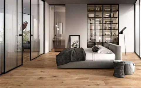 Modern bedroom with glass doors, a bed, and a wardrobe. The doors are designed to transform a hinged door into a sliding one, saving space.