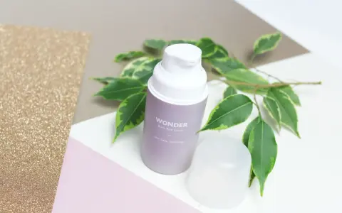 Wondeful! Serum z czarnego ryżu Haru Haru Wonder, otoczone zielonymi liśćmi, na tle błyszczącego złota i pastelowych kolorów.