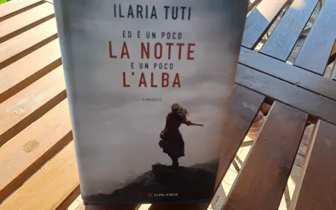 Copertina del libro "Ed è un poco la notte e un poco l'alba" di Ilaria Tuti, con una figura femminile su uno sfondo nebbioso.