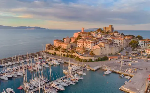 Porto con borgo medievale e castello, ideale per scoprire cosa visitare in Maremma in 3 giorni.