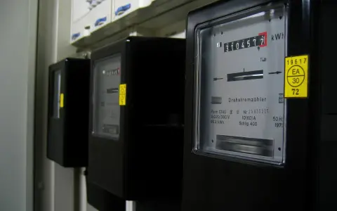 Trzy liczniki energii elektrycznej, jeden z nich pokazuje 3104577 kWh, czyli zużycie energii.