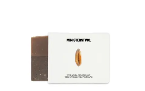Brązowe mydło z orkiszem, którego składnikiem jest sodium palmate, obok białego opakowania z logo MINISTERSTWO. i ziarnem.