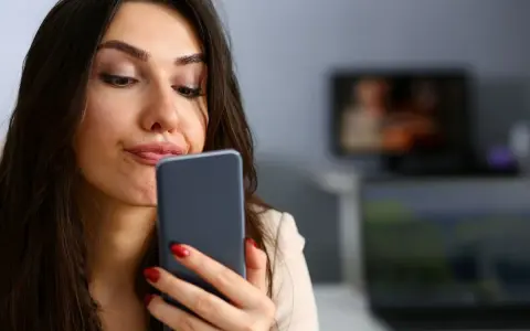 Zastanawia się, czy muszę odbierać telefon od ojca dziecka. Wyraz twarzy sugeruje niepewność.