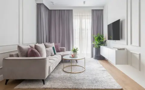 Elegancki salon z sofą i stolikiem kawowym, gdzie **modern classic** styl łączy się z przytulnością.