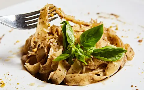 Wide tagliatelle z parmezanem i bazylią, kuszące aromatem, który zdradza, jaki smak ma trufla.
